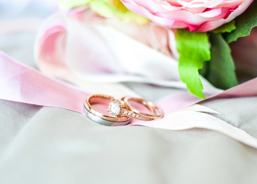 rose gold wedding band set on flowers.