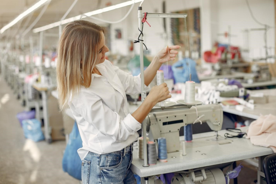 woman working with a sewing machine in an embroidery factory.