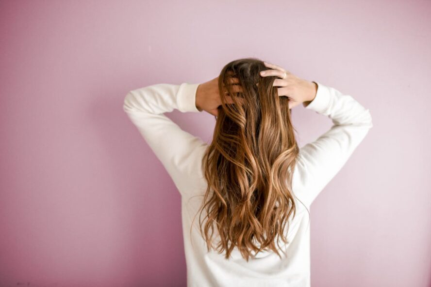 Woman running her fingers through her long blond hair, .