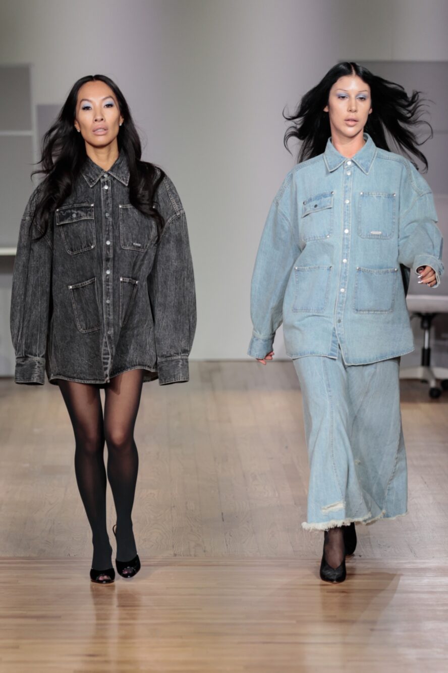 2 models. The model on the left is wearing a dark grey oversized jacket and tights. The model on the right is wearing a light blue oversized jacket and jeans.