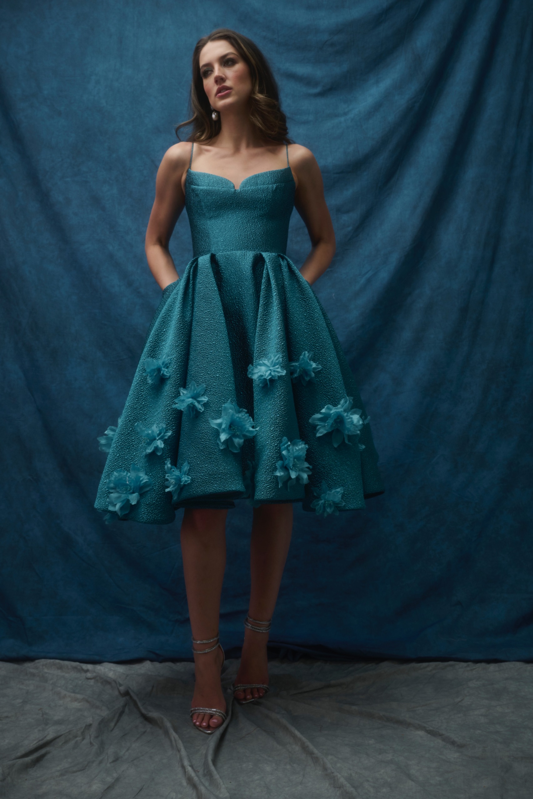 A model wearing a blue/green dress.