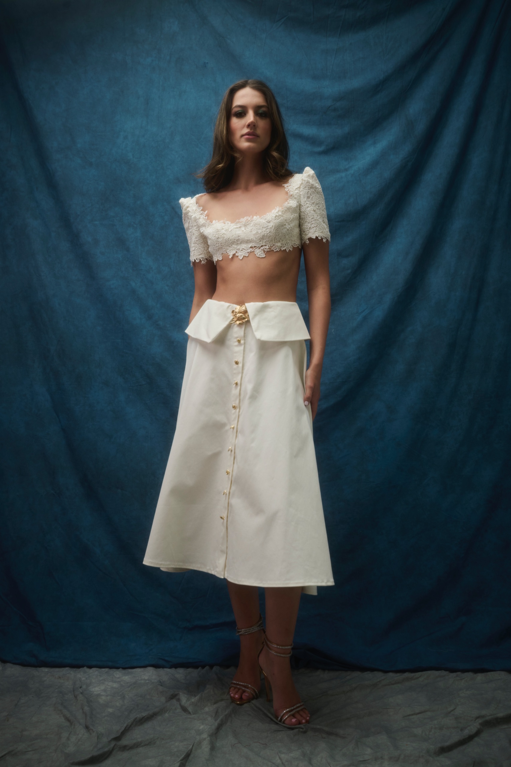 A model wearing a white top and white skirt.