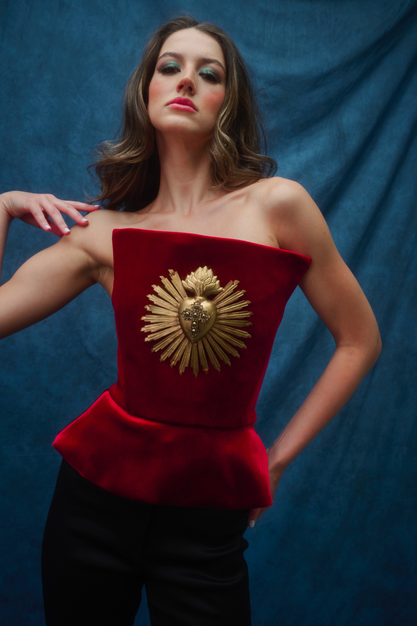 A model wearing a red top with gold embellishment.