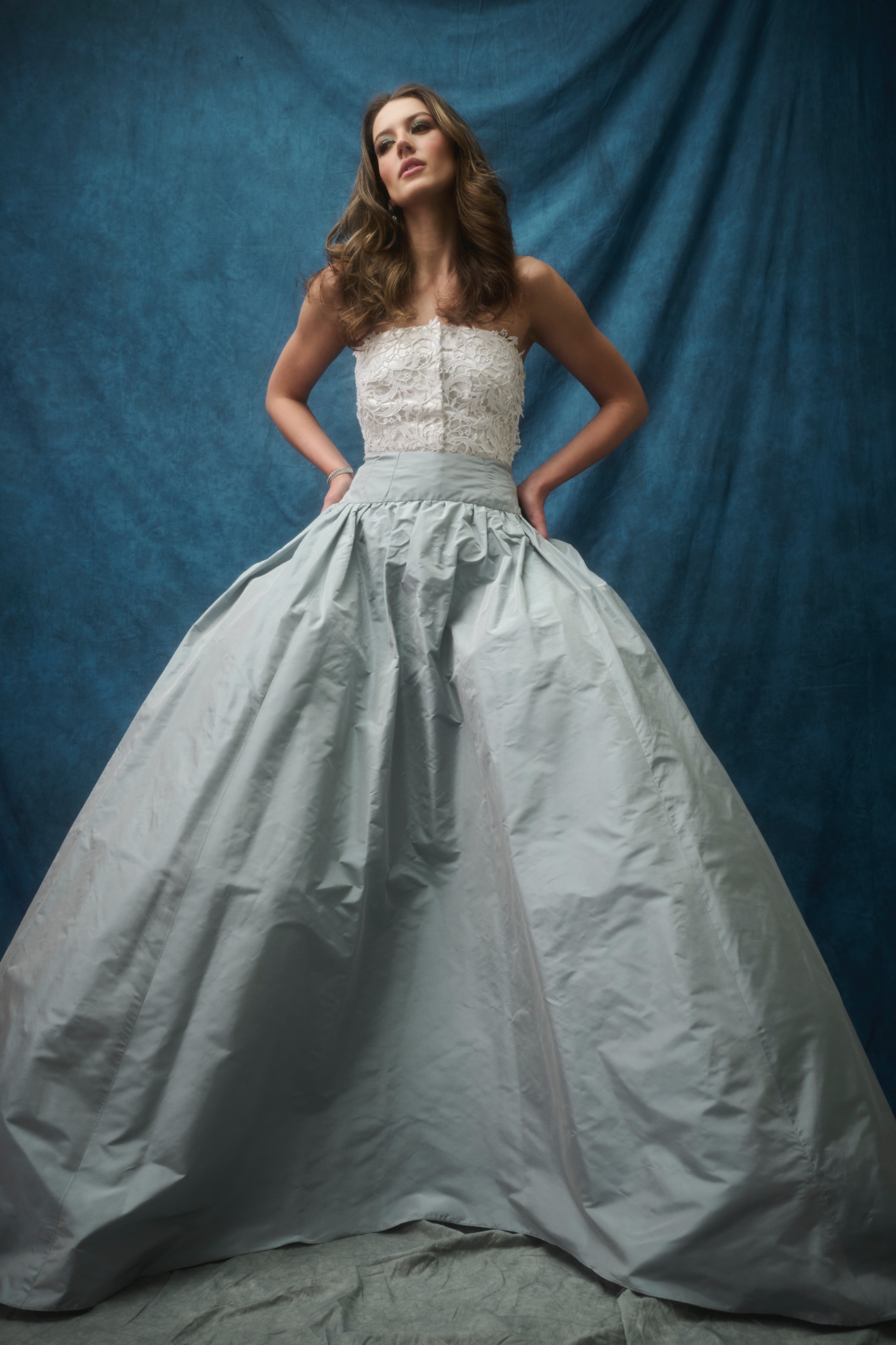 A model wearing a dress with a white top and grey skirt.