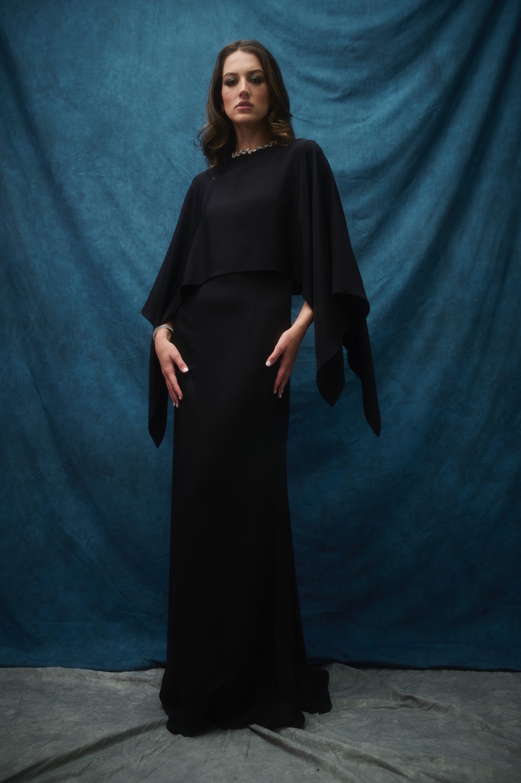 A model wearing a long-sleeved black dress.