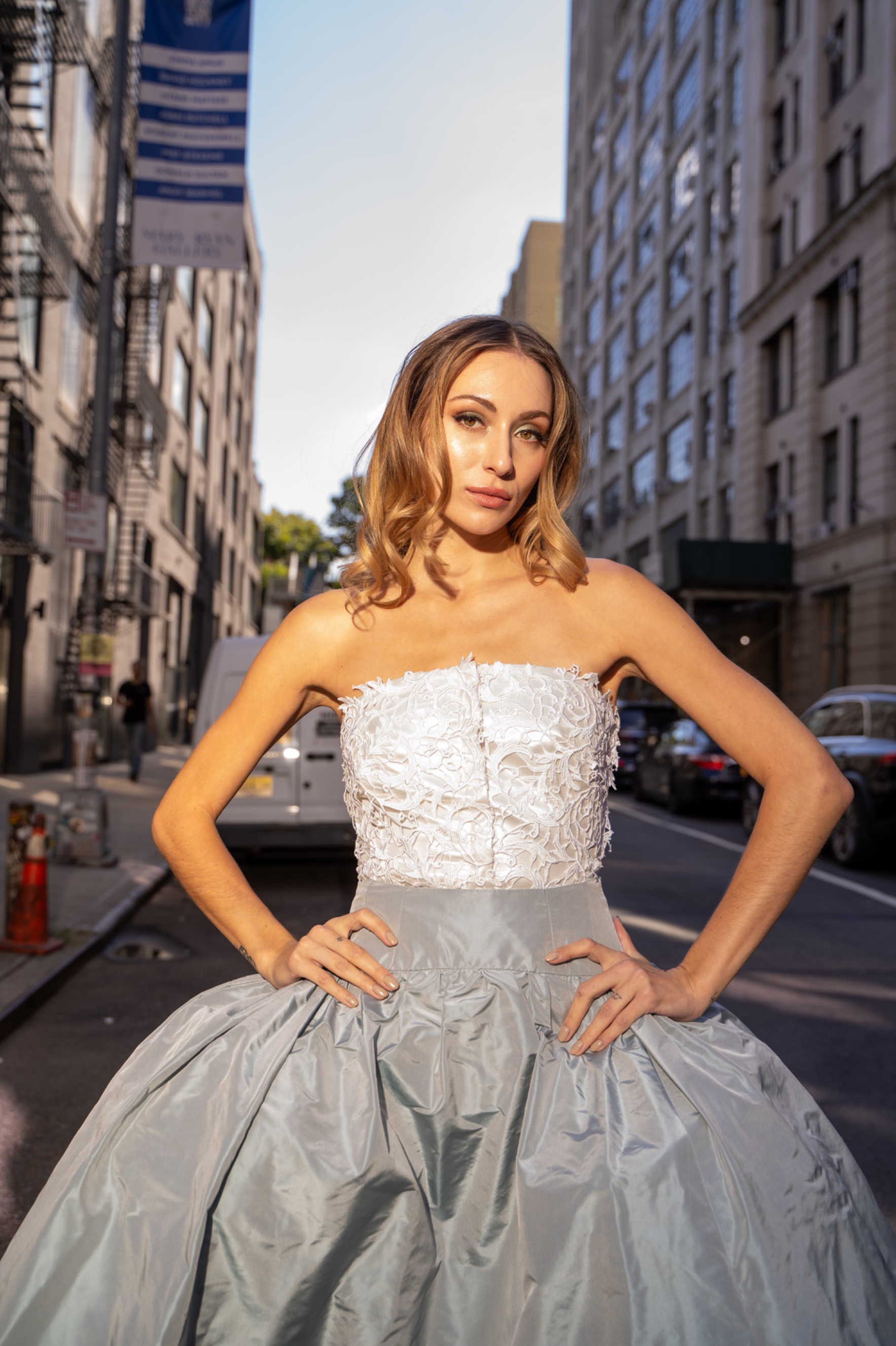 A model wearing a dress with a white top and grey skirt.