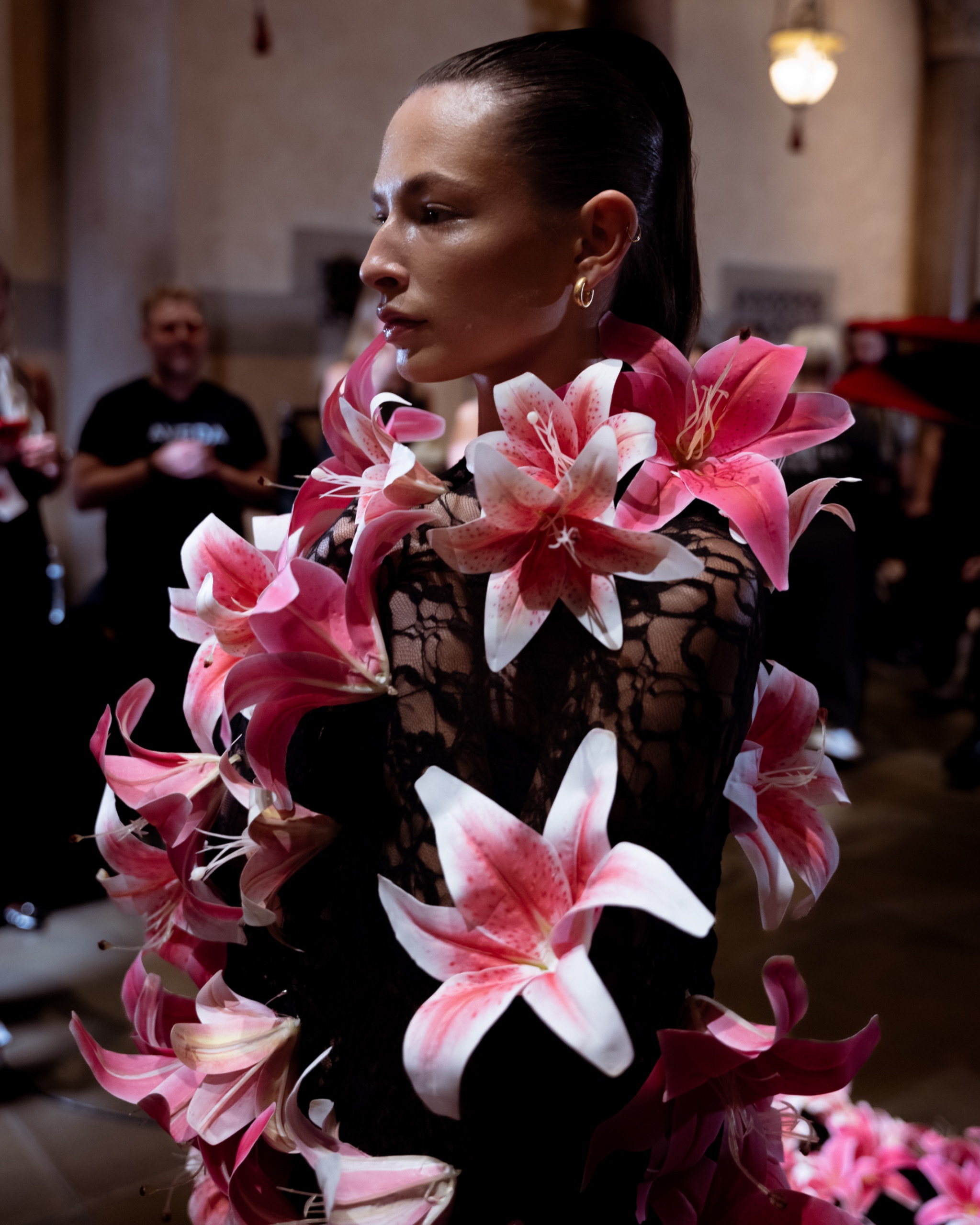 A model wearing a black dress with pink and white lilies.