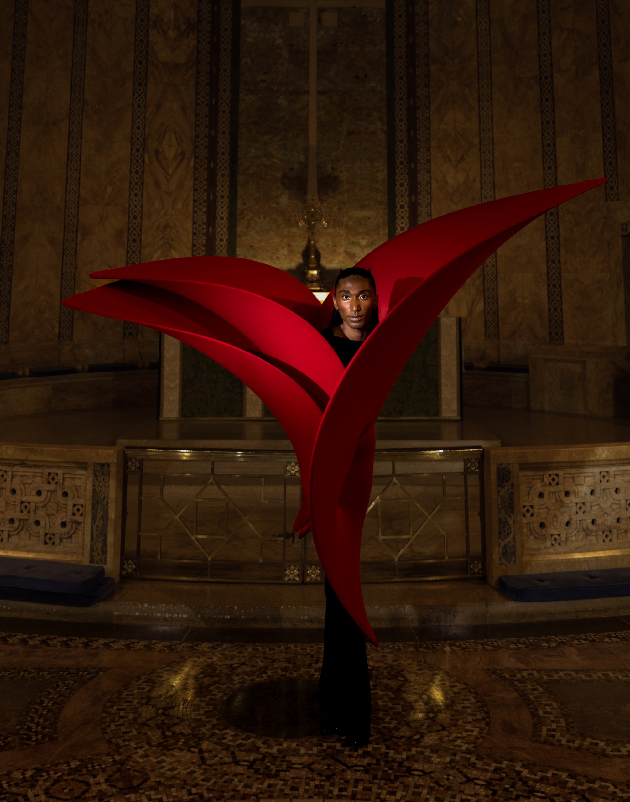 Model wears red dress with flower-like silhouette.