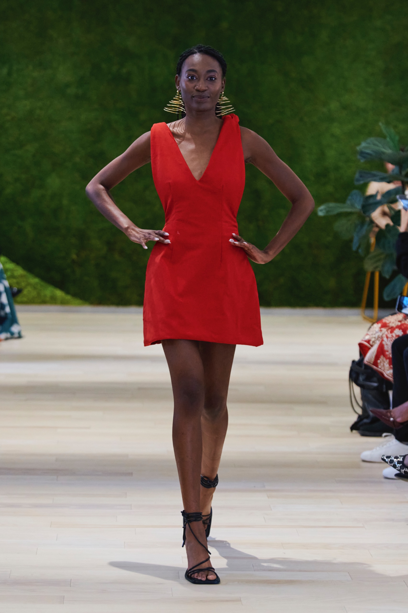 A model walking the runway wearing a red dress.