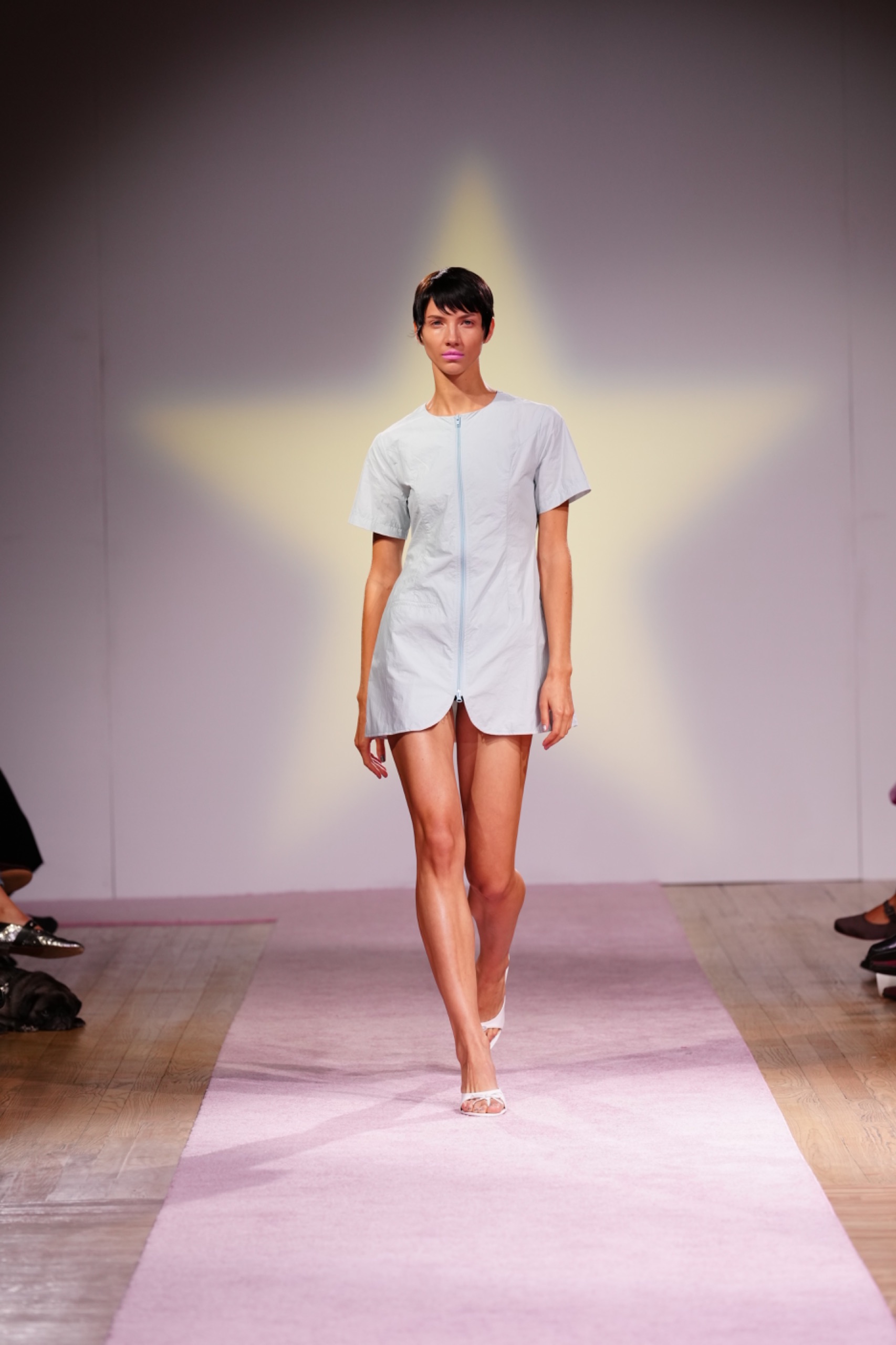 A model walking the runway wearing a blue dress.