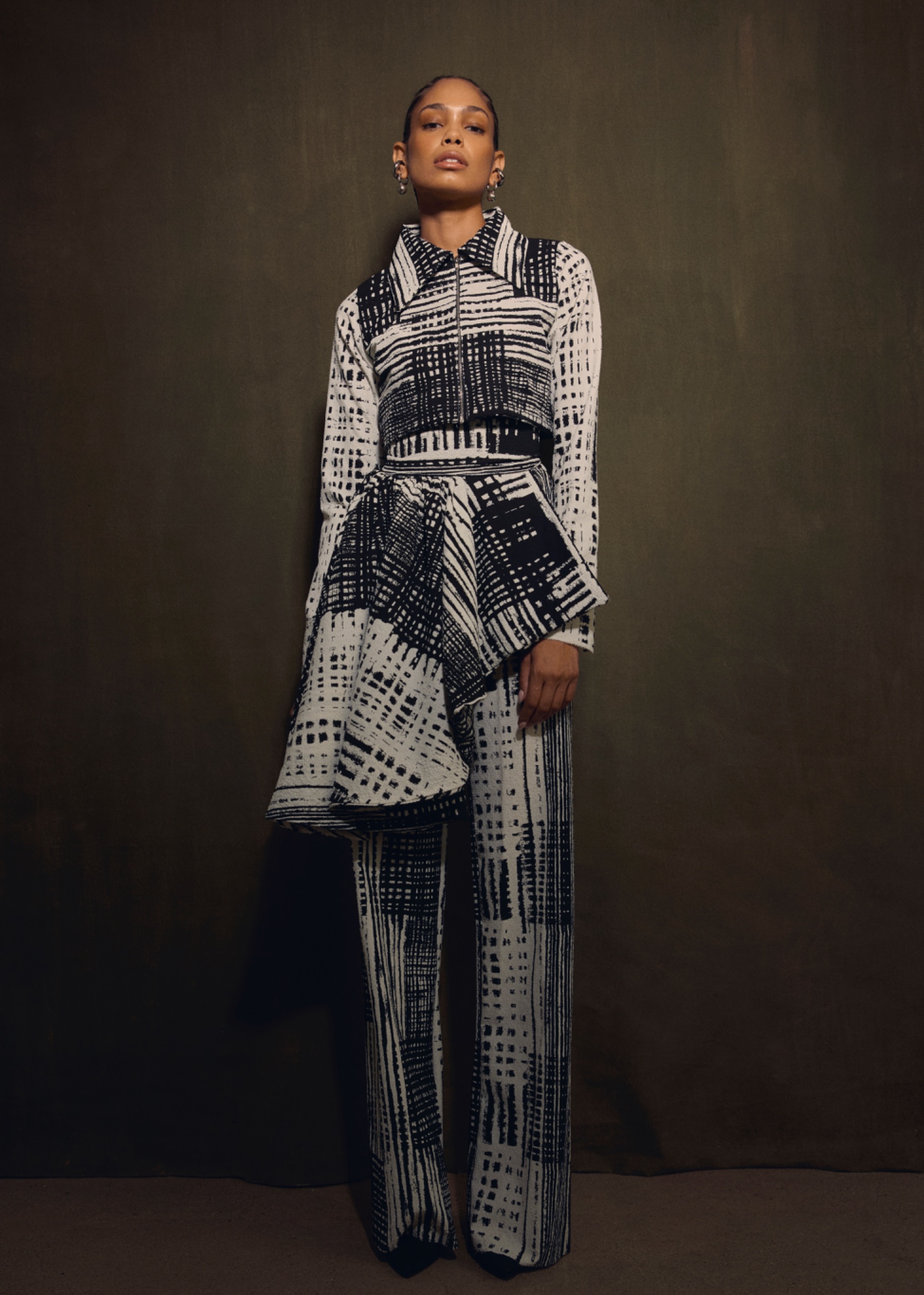 A model wearing a black and white pattern dress.