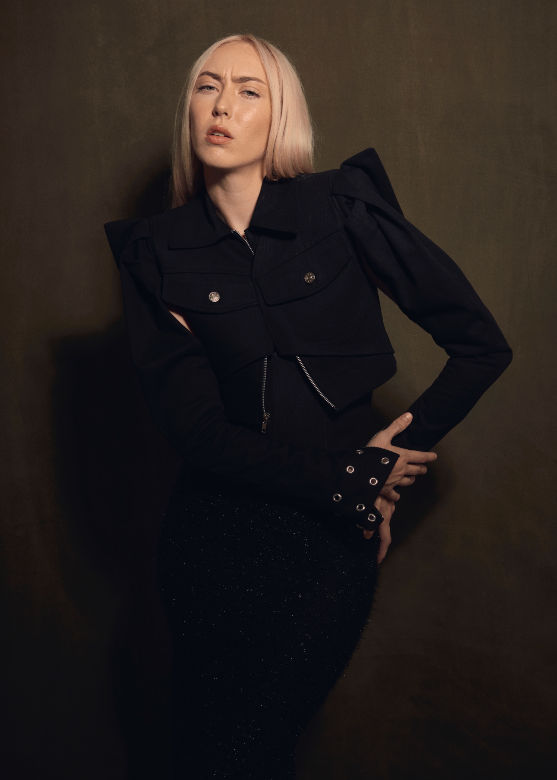 A model wearing a black jacket and black bottoms.