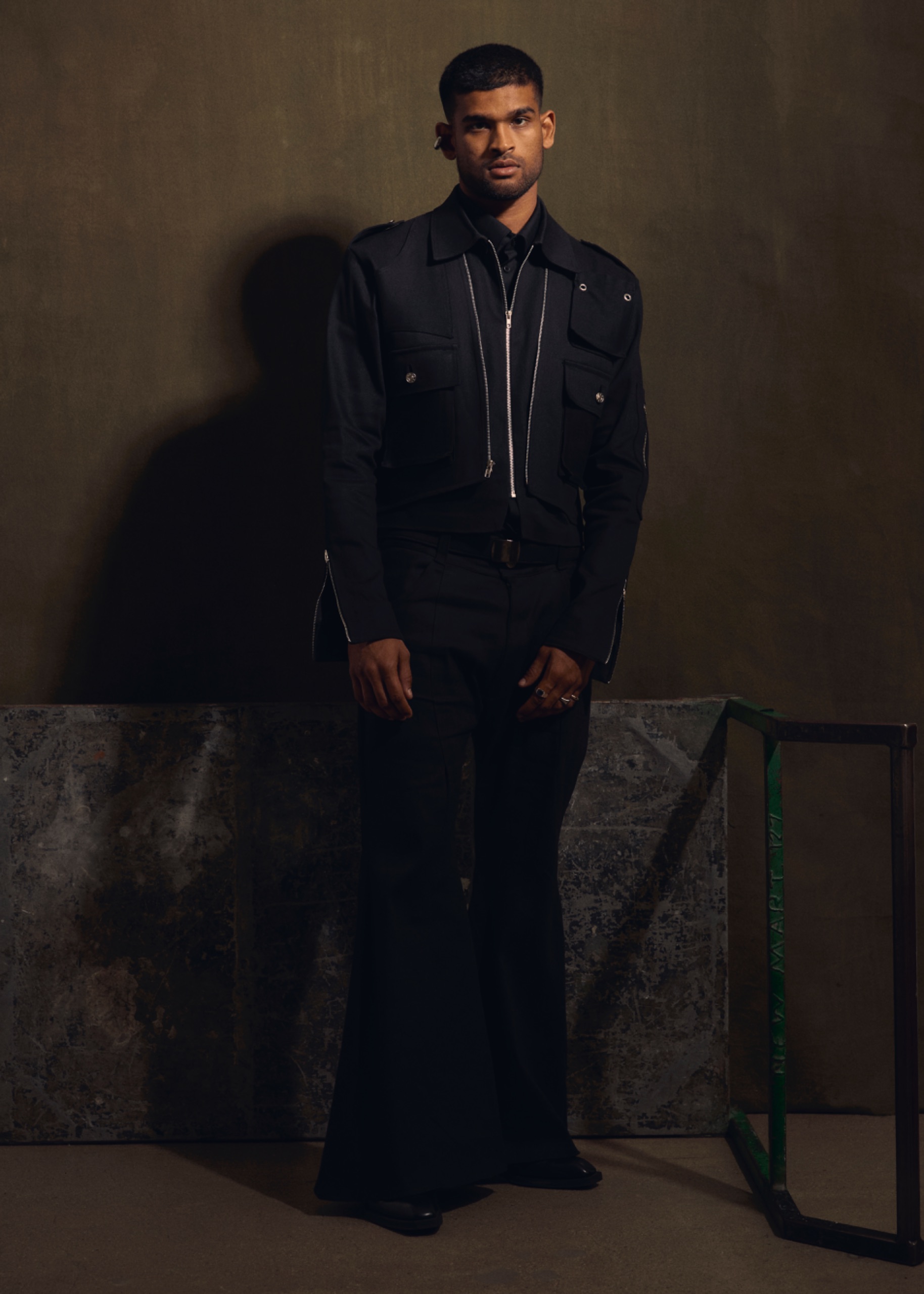 A model wearing a black jacket and pants.