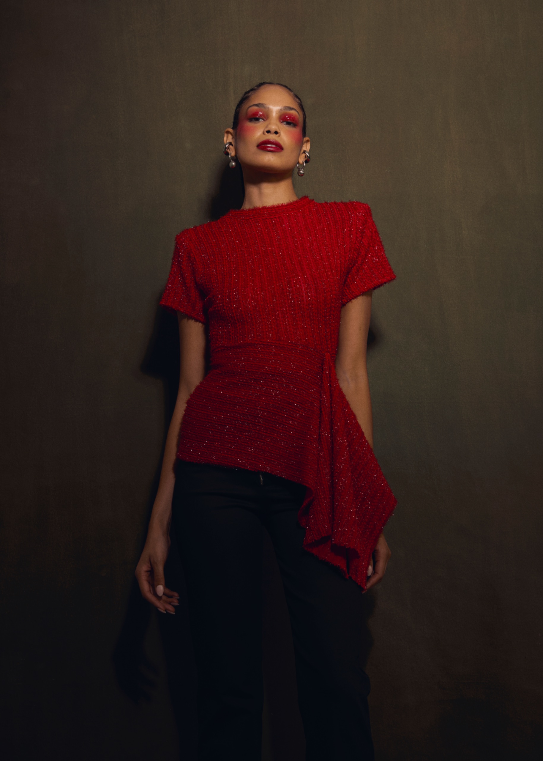 A model wearing a red top and black skirt.