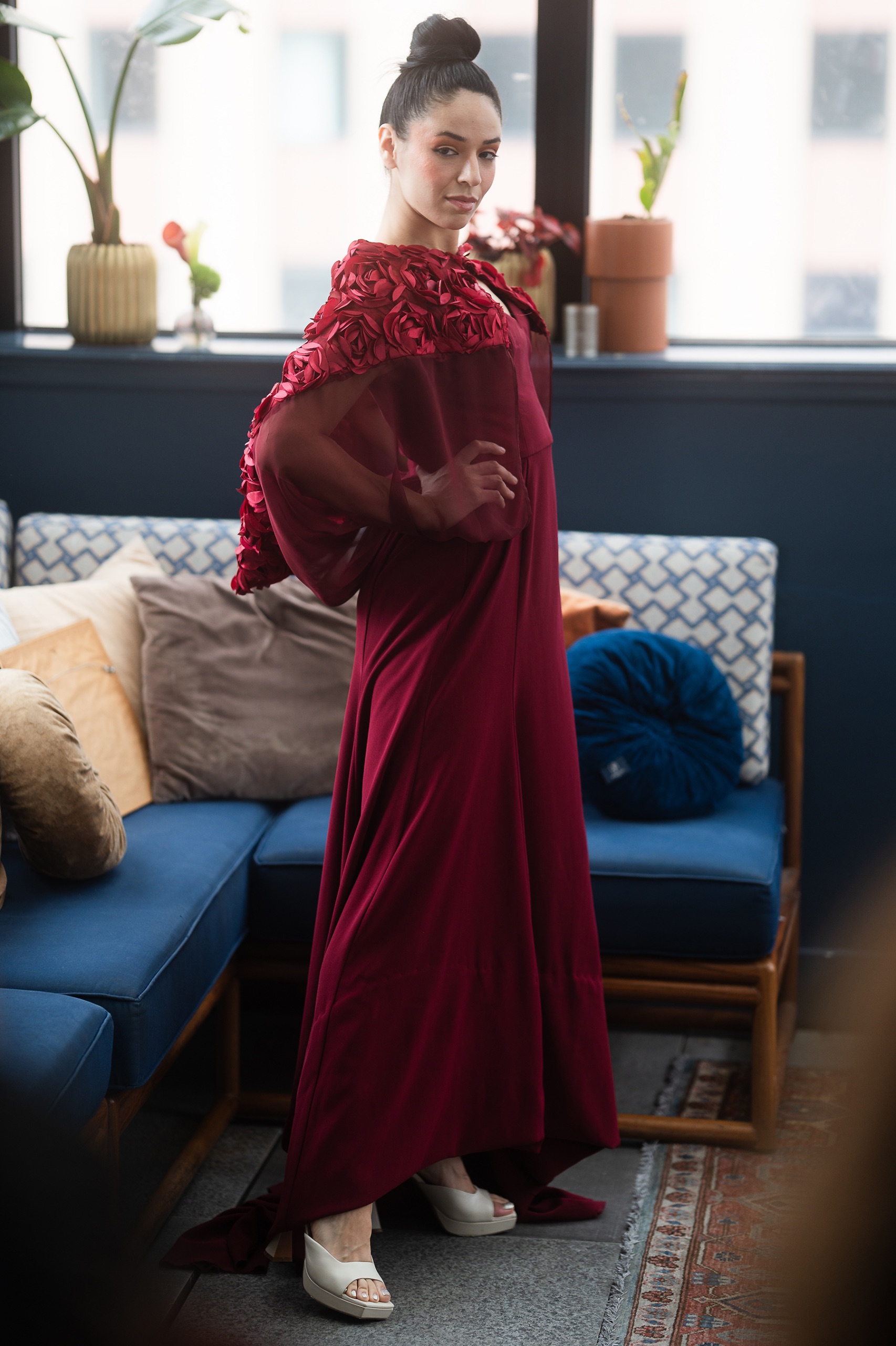 A model wearing a long maroon dress.