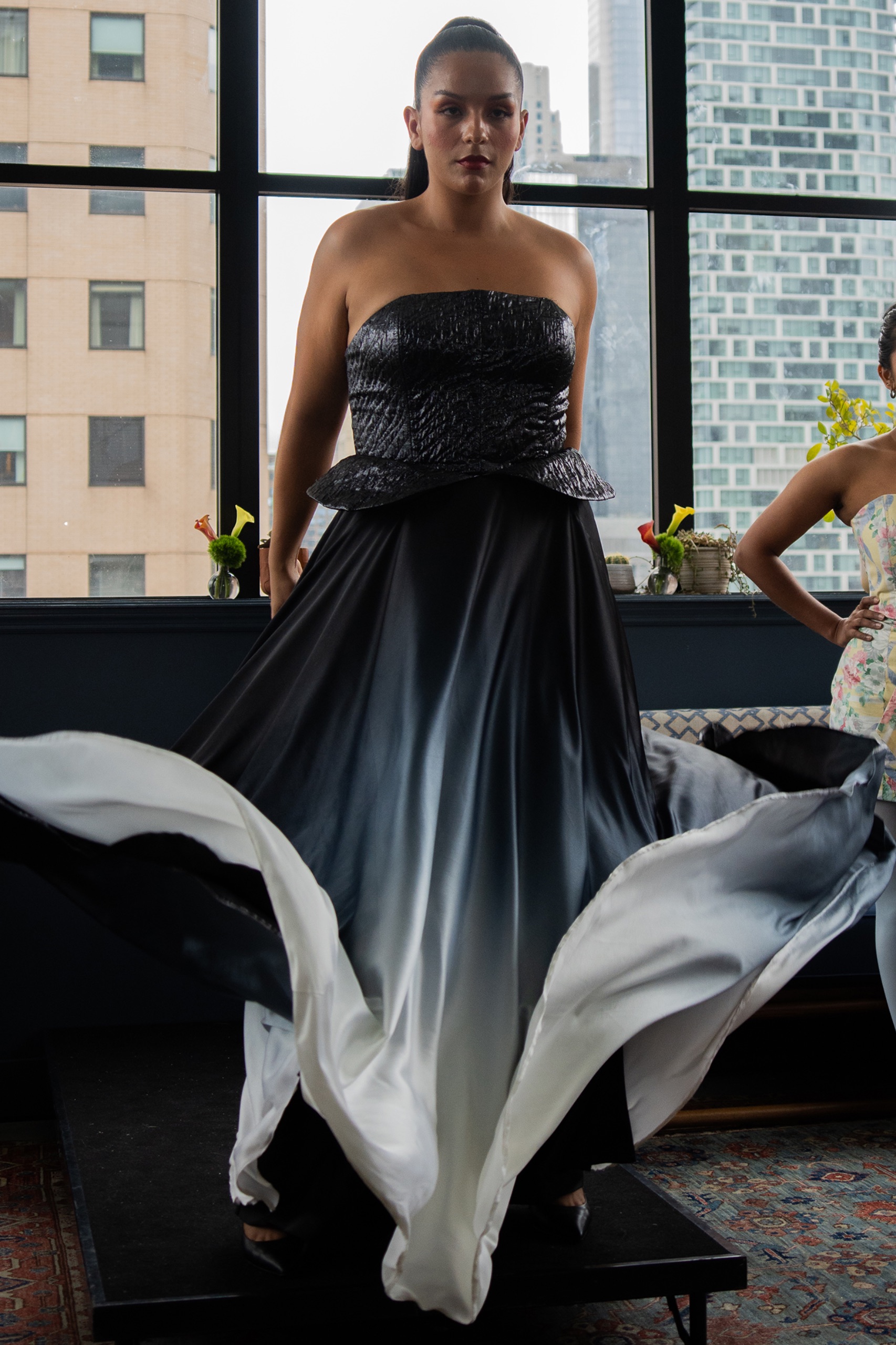 A model wearing a long black and white dress.