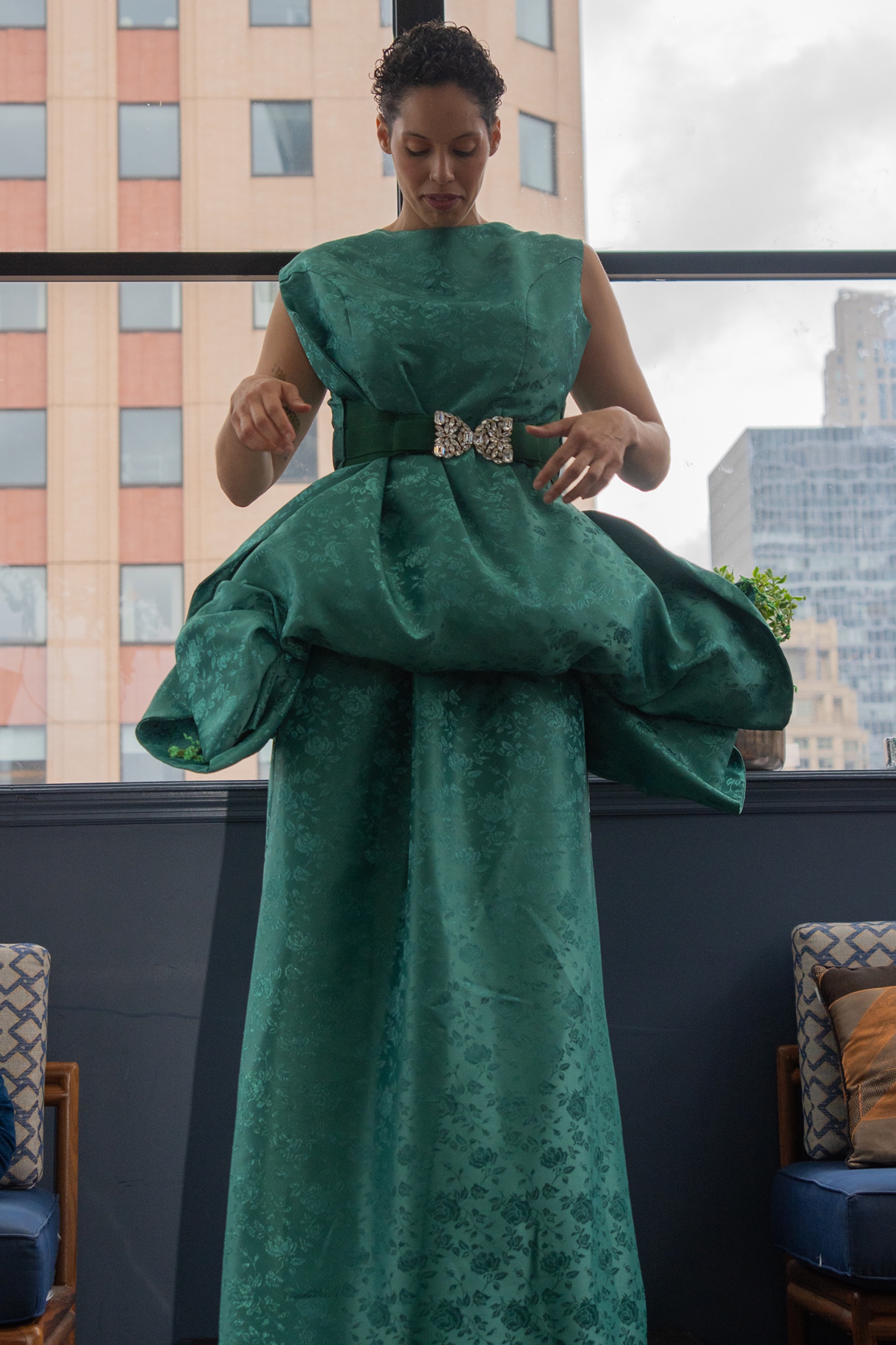 A model wearing a long green dress.