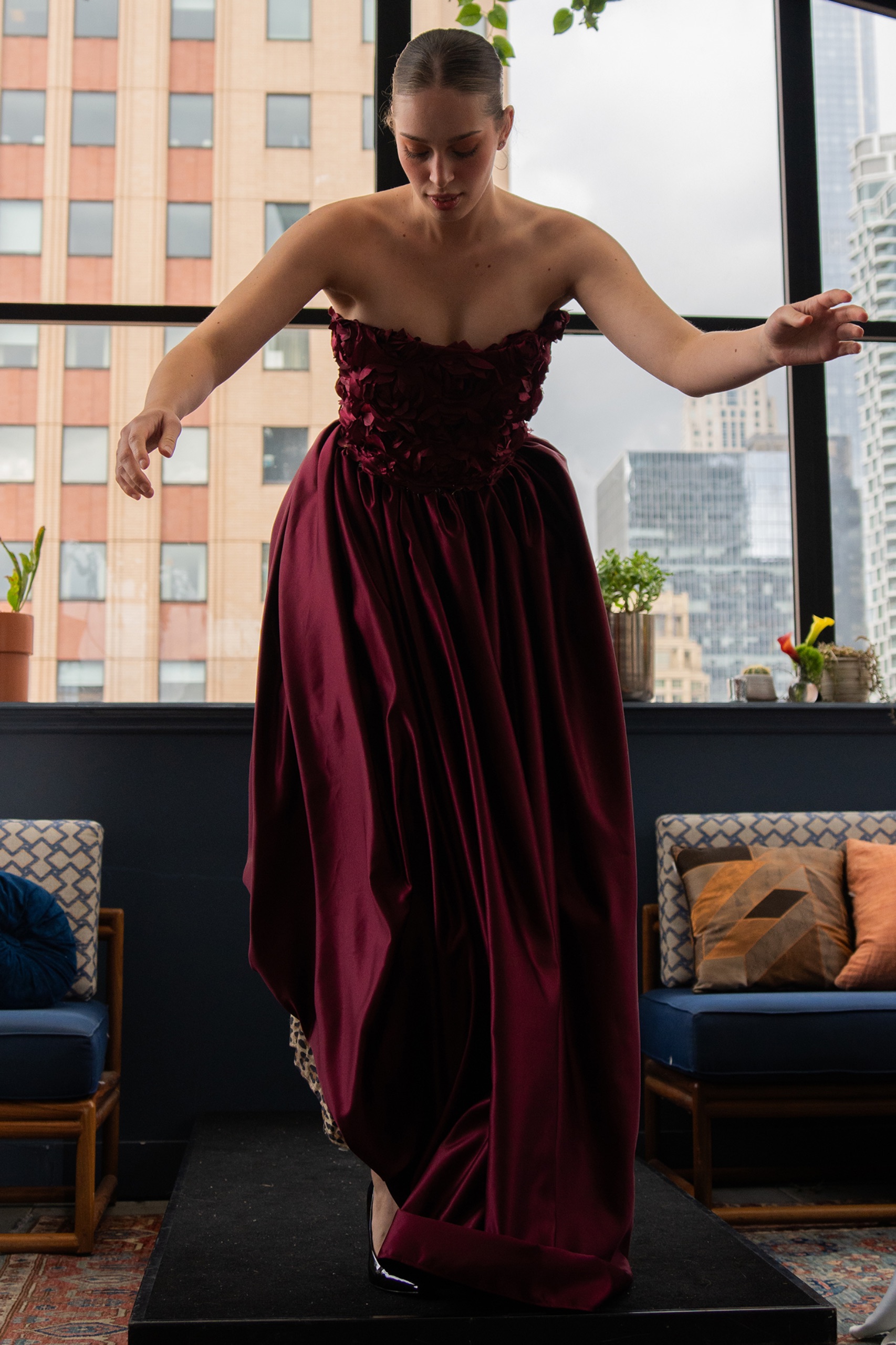 A model wearing a long maroon dress.