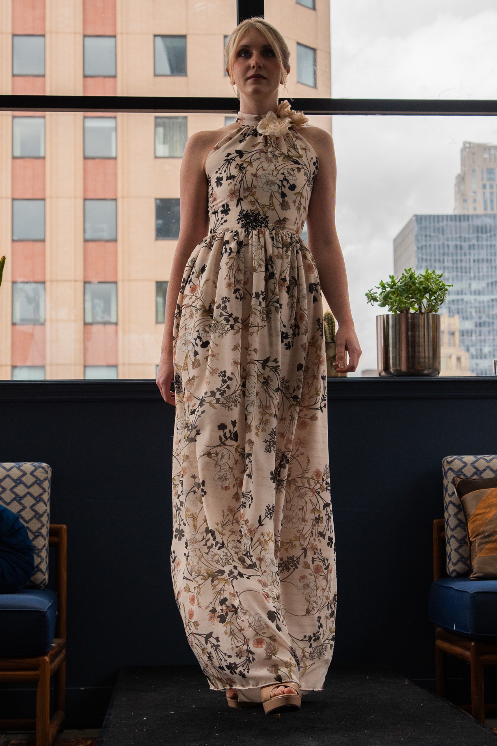 A model wearing a long floral dress.