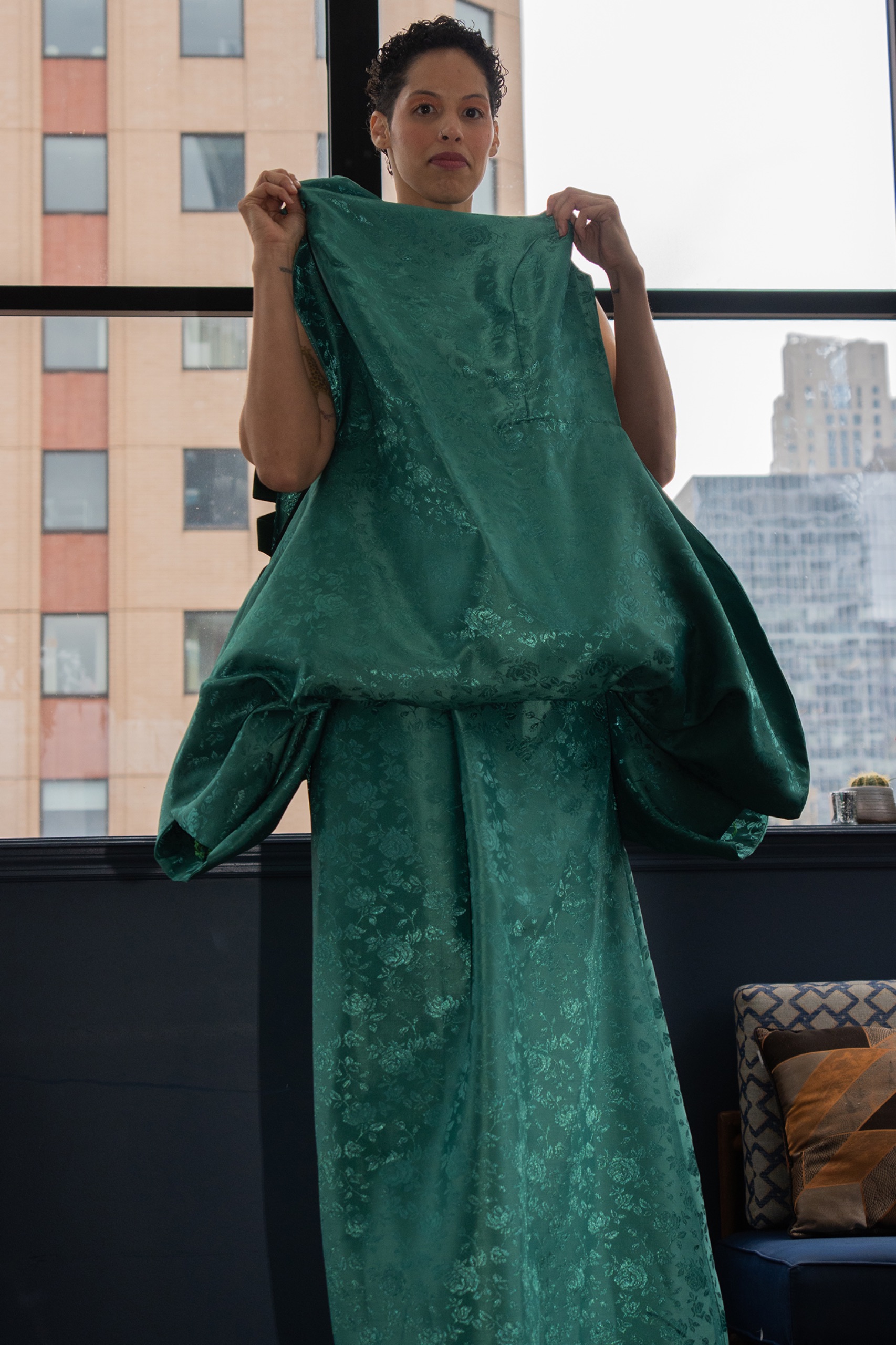 A model wearing a long green dress.