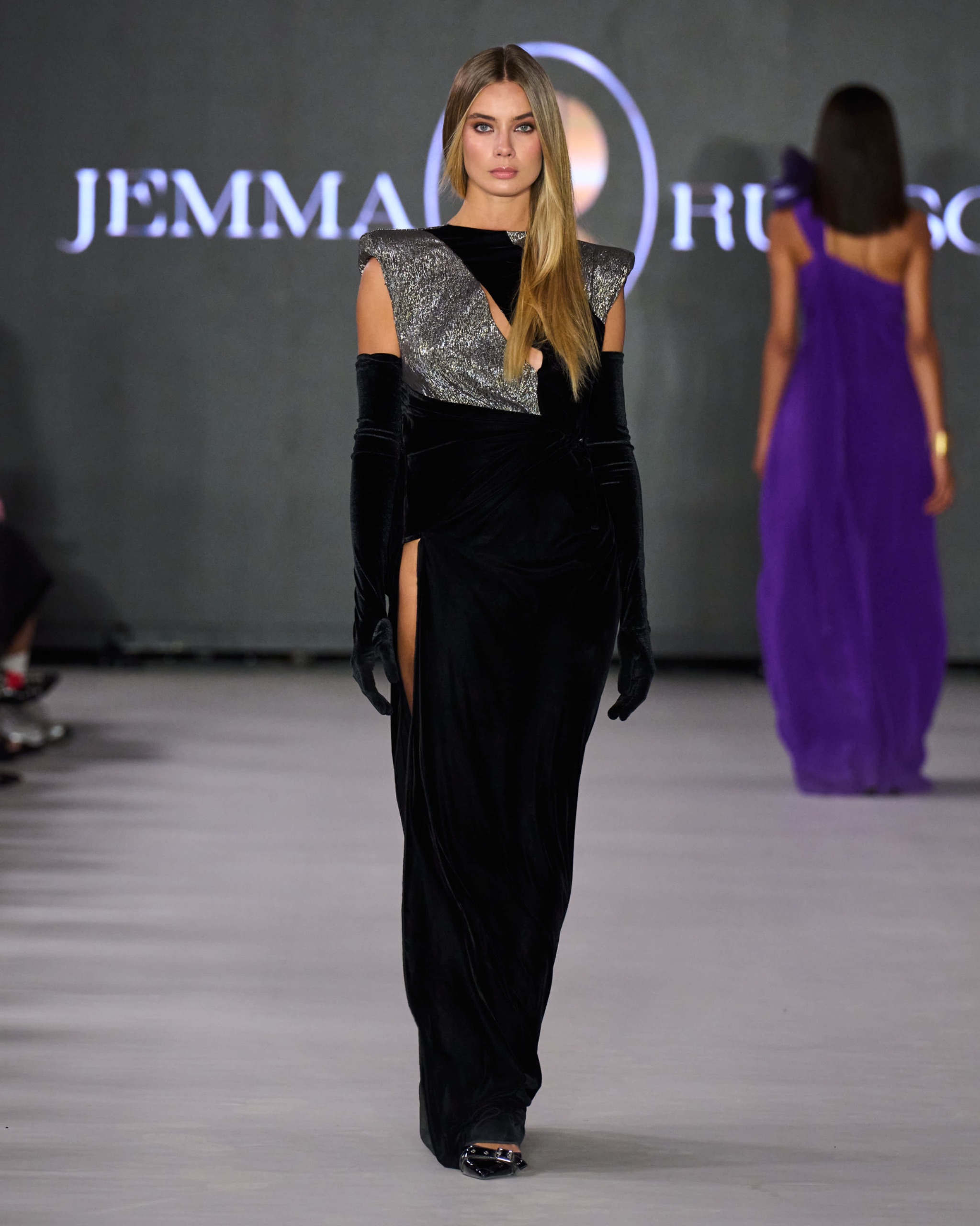 A model walking the runway wearing black outfit.