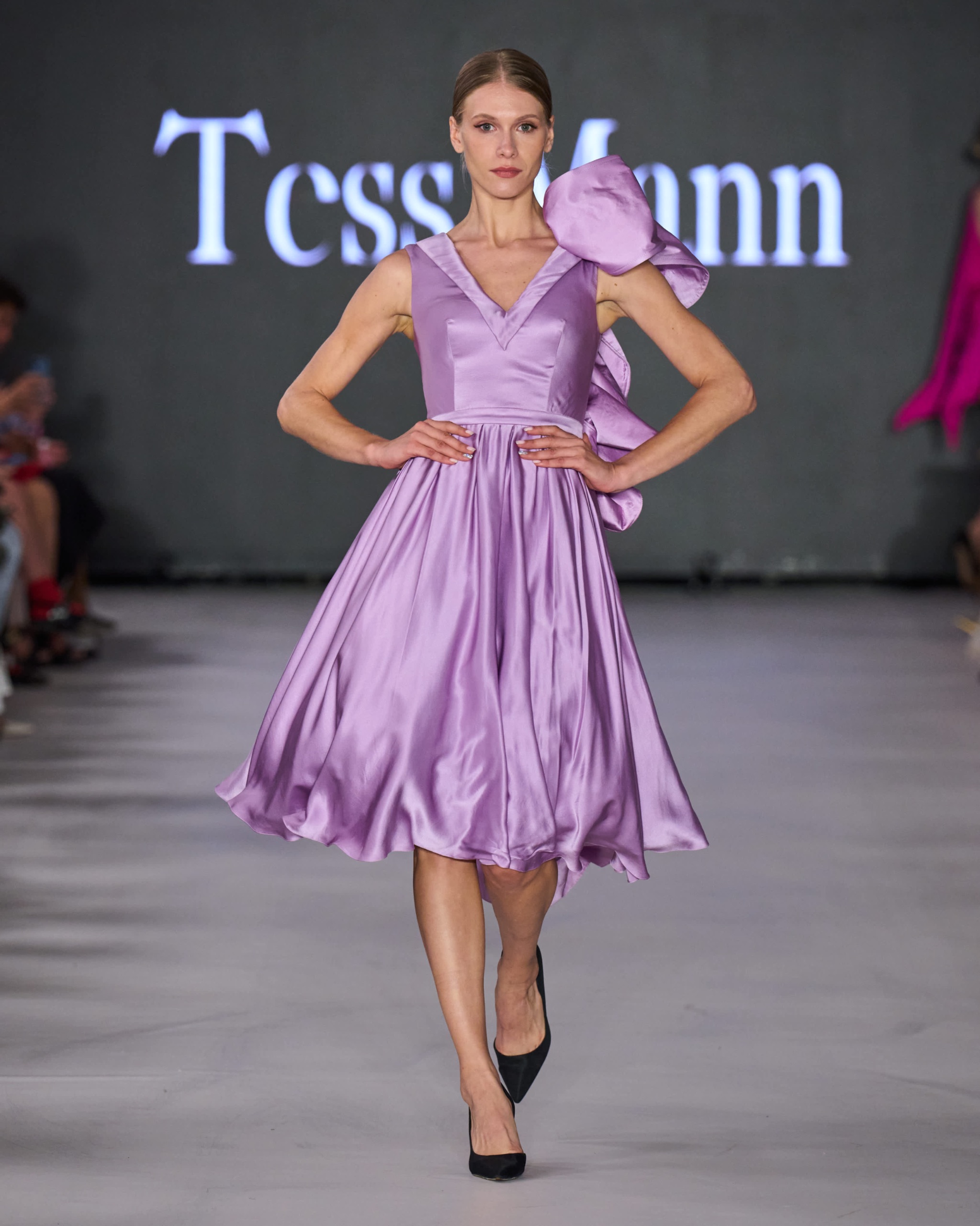 A model walking the runway wearing a lavender dress.